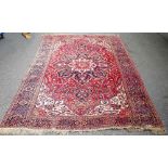 An antique Tabriz carpet with a lobed medallion and all-over floral design on a red ground,