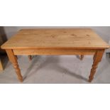 A pine rectangular kitchen table with single frieze drawer on turned supports,