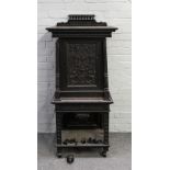 A 19th century Dutch ebony and ebonised carved side cabinet with carved panel door over drawer