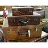 A group of three early 20th century leather suitcases, the largest 70cm wide x 27cm high,