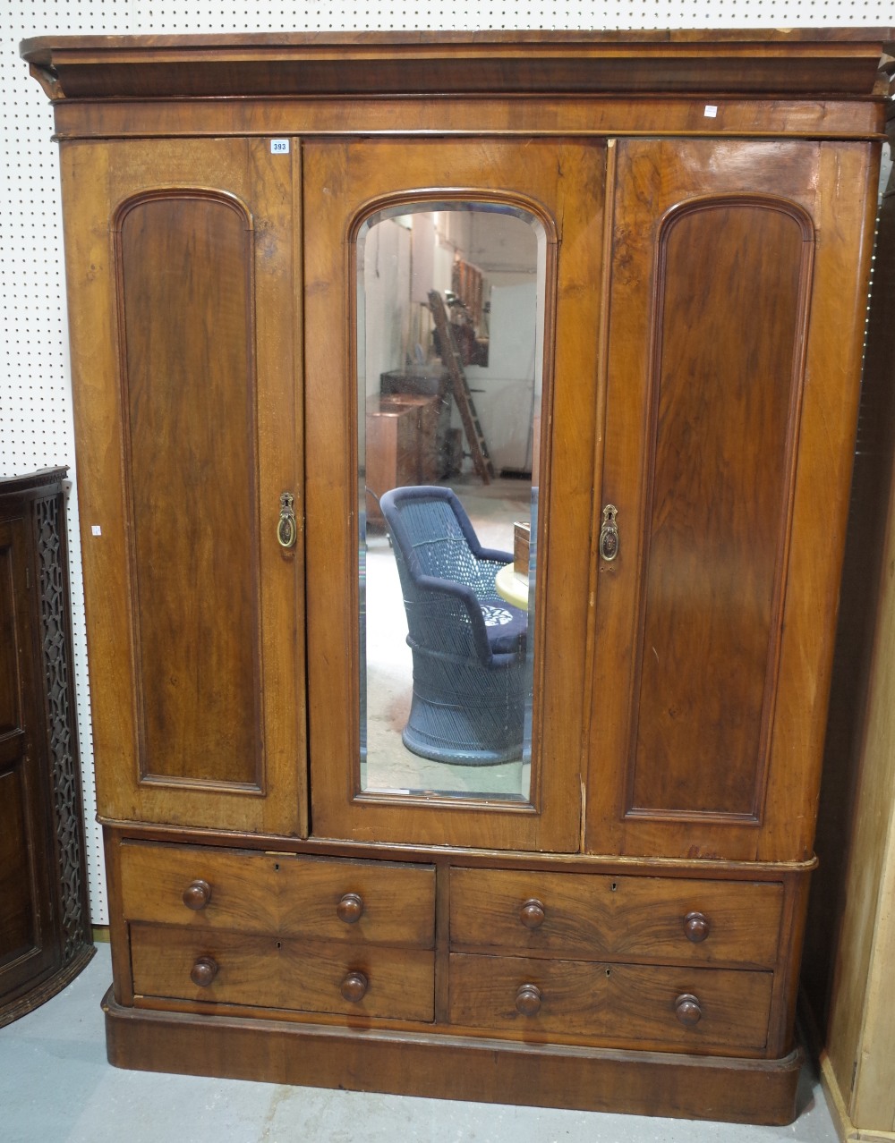 A Victorian mahogany triple wardrobe with mirrored door on plinth base.