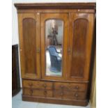 A Victorian mahogany triple wardrobe with mirrored door on plinth base.
