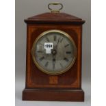 A mahogany and inlaid mantel clock with a six inch silvered dial and single train fusee movement,