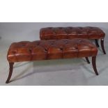 A pair of 20th century window seats with faux brown leather button upholstery on sabre supports,