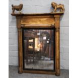 A small Regency gilt mirror with opposing lion and dog finials,