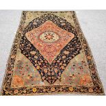 A Malayer rug, Persian, the black field with a large madder diamond, with central ivory roundel,