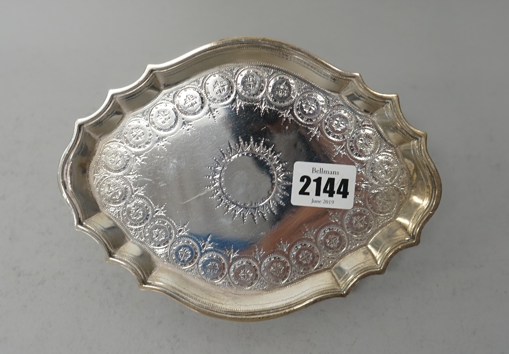 A George III silver teapot stand, of shaped oval form, with bright cut engraved decoration,