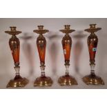 A set of four modern amber glass and gilt metal mounted candlesticks,