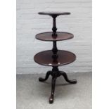 A George III mahogany circular graduated three tier dumb waiter, on tripod base,