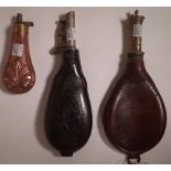 A group of three 19th century French shot flasks, the largest with embossed leather 23cm long,
