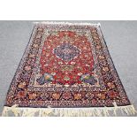 An Isfahan carpet, burgundy red field with circular mandala shaped medallion,