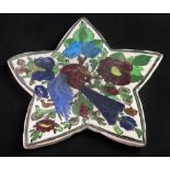 A Qajar star shaped tile, 20th century, painted with a bird and flowering branches, 34 x 32.5cm.