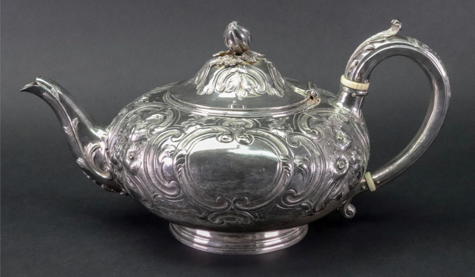 A Victorian compressed circular silver teapot, Joseph Angell, London 1854, embossed with flowers,
