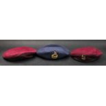 A blue beret, by Gieves, with the insignia of the Royal Air Force and two 'red berets', by J.C.S.
