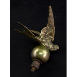 A vintage brass car mascot cast in the form of a bird in flight above a sphere, Rd. No. 560299, 11.