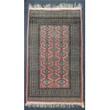 A Pakistan Bokhara rug with two rows of seven motifs flanking a central row of six,