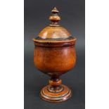 A turned fruitwood cup and cover, 18th century, the domed pull off cover with a turned finial,