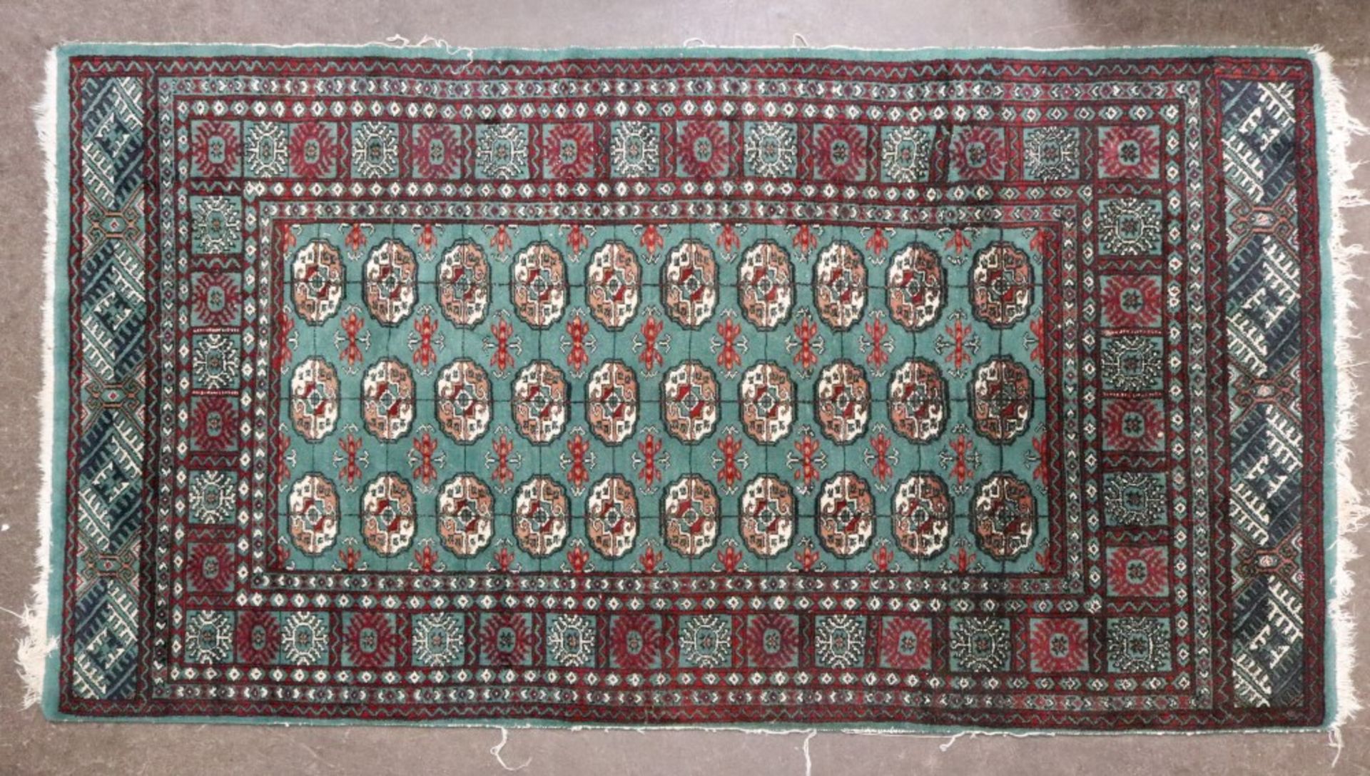 A Pakistan Bokhara rug, the green field with three rows of ten quartered gulls, 194 x 121cm.