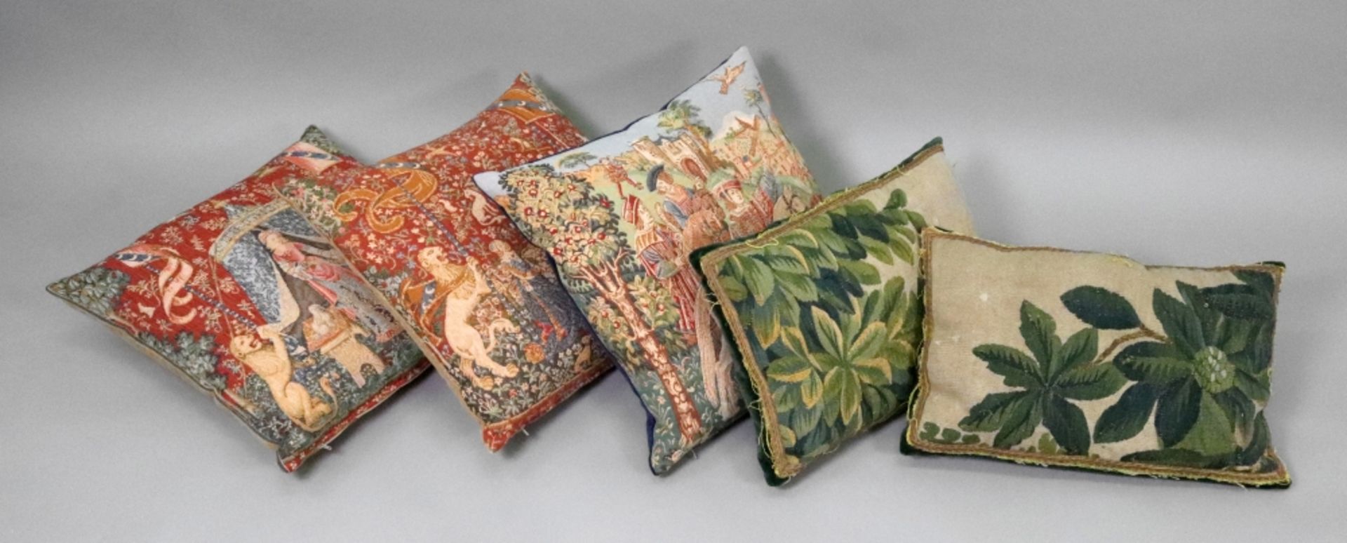 A pair of cushions, the fronts fragments from 17th/18th century tapestries, decorated with leaves,