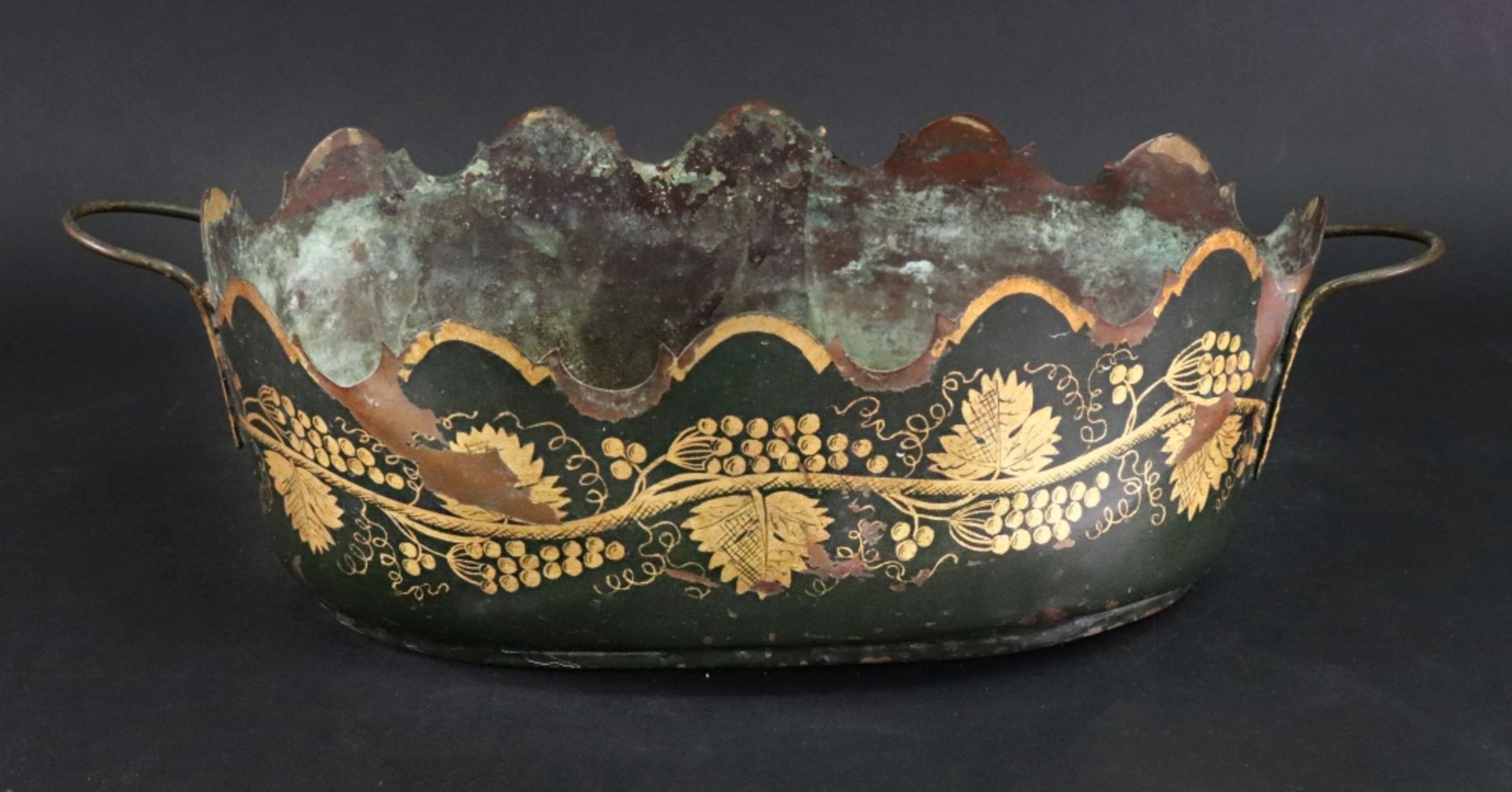 A French tole peintre oval two handled jardiniere, gilt with fruiting vines against a green ground,