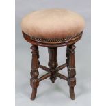 A late Victorian mahogany piano stool, with circular revolving upholstered seat, on turned,