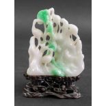 A Chinese jade carving, 20th Century, of four storks amongst trees and rockwork, 8cm high,