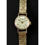 Longines; a lady's 9ct gold bracelet watch, the dial with raised baton hour markers and hands,