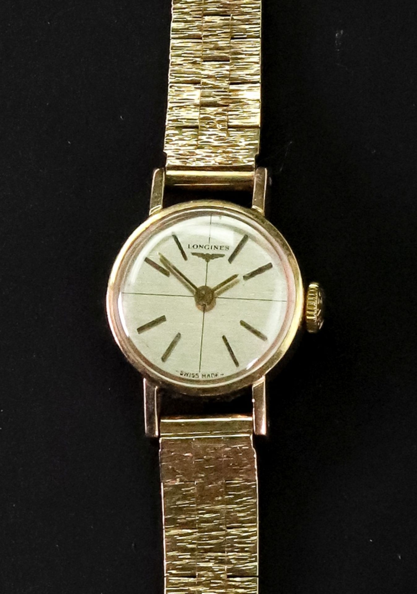 Longines; a lady's 9ct gold bracelet watch, the dial with raised baton hour markers and hands,