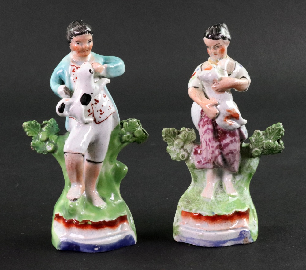 A pair of English pearlware figures modelled as a boy and girl, circa 1820,