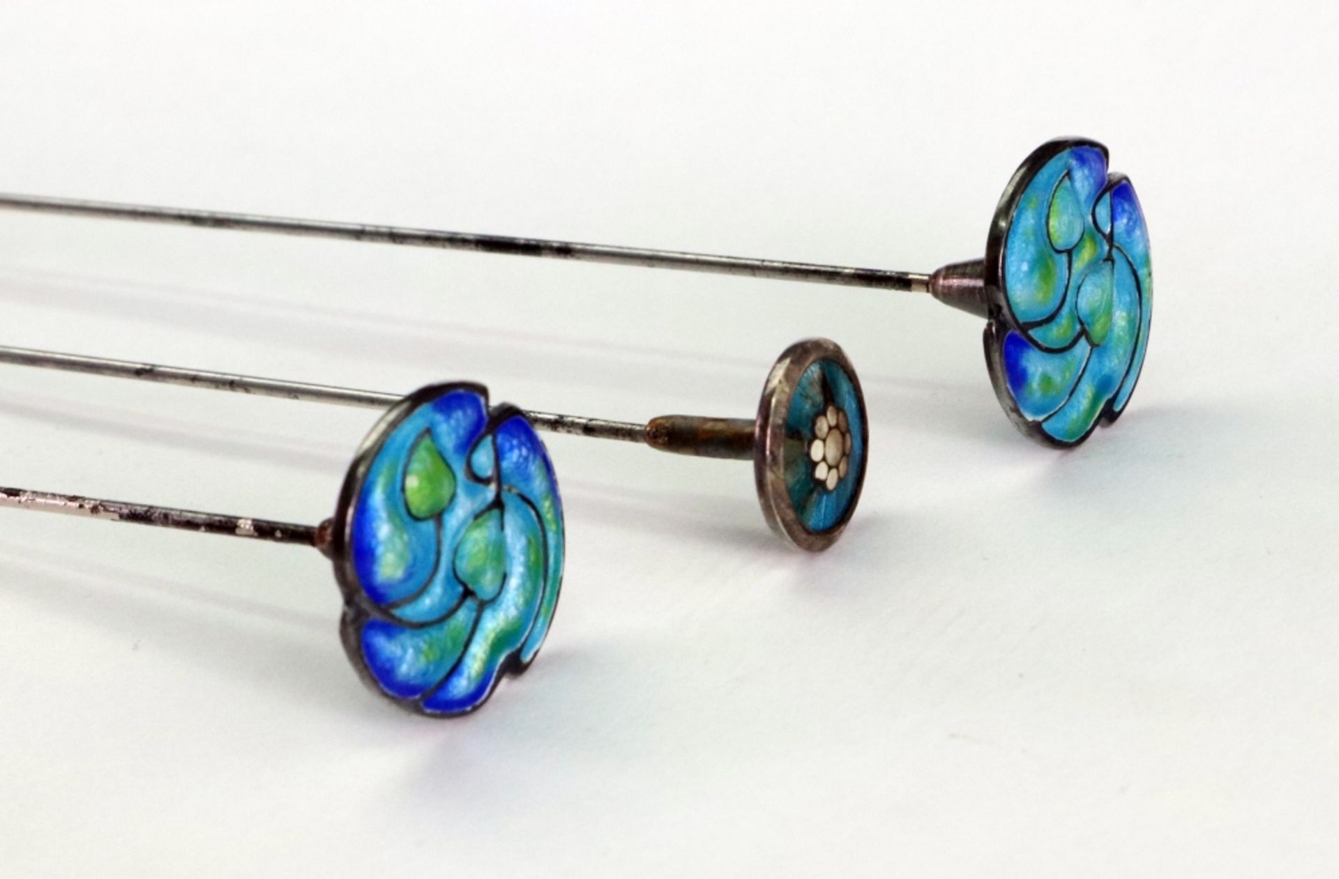 A graduated pair of Art Nouveau mounted steel hat pins, enamelled with leaves, - Image 2 of 2