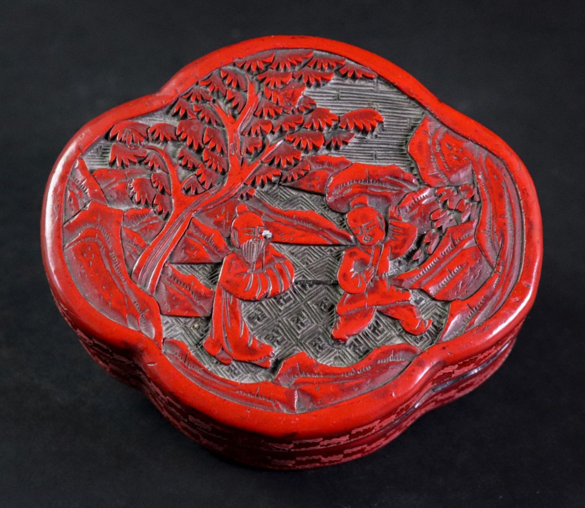 A Chinese cinnabar lacquer box, 19th century, of quatre lobed form, with lozenge carved sides,