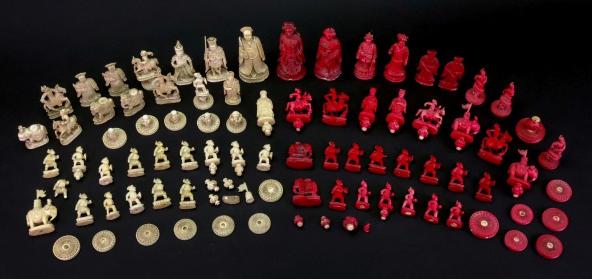 A collected Chinese carved ivory chess set, 19th century, one half stained red, the kings 9cm high.