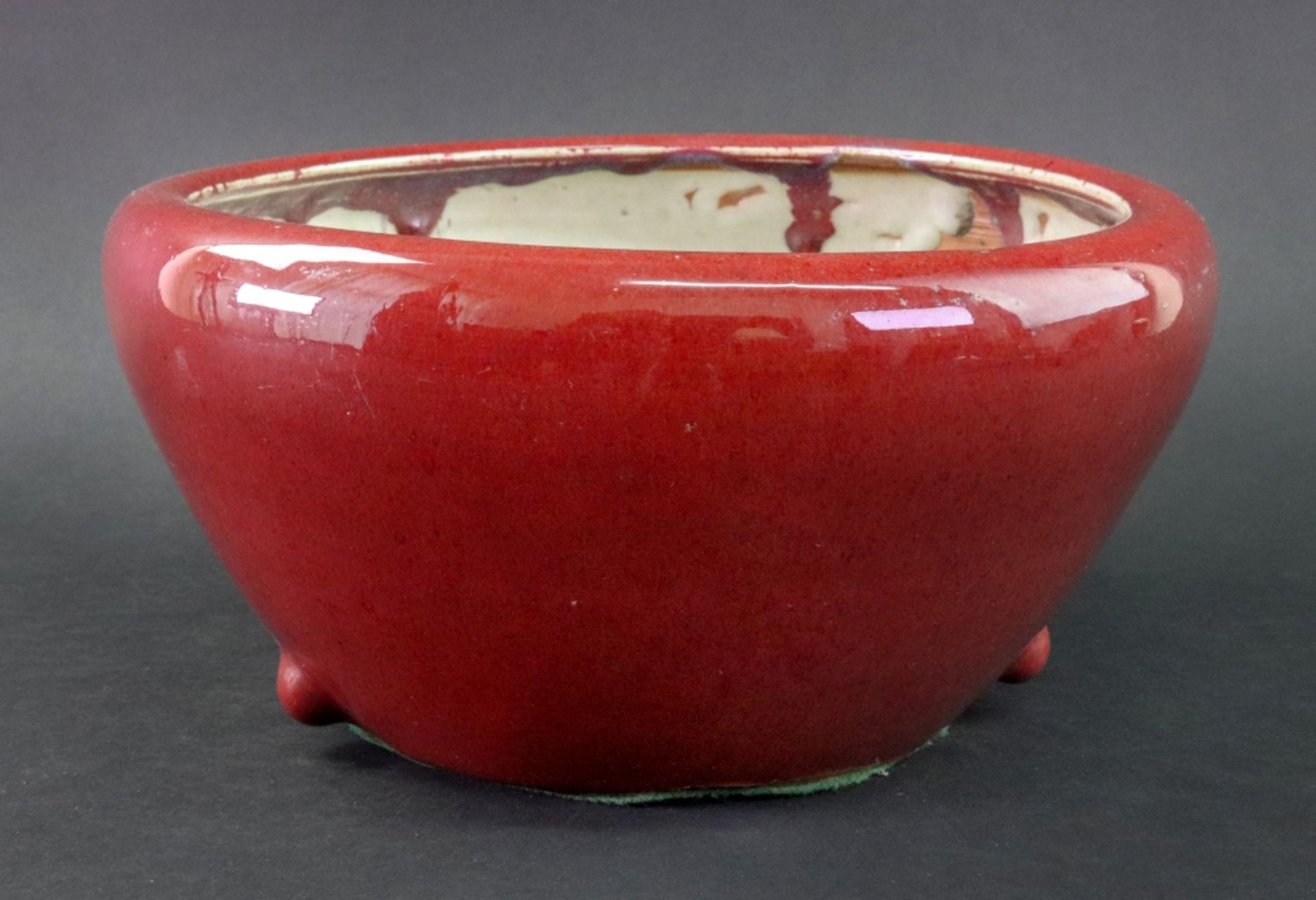 A Chinese flambe glazed jardiniere, 19th/20th century, covered in a deep red glaze, 27cm. diameter.