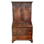 An early 18th century walnut cross and feather banded bureau cabinet,