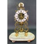 A Victorian brass skeleton clock, of open scrollwork form, the silvered dial with Roman numerals,