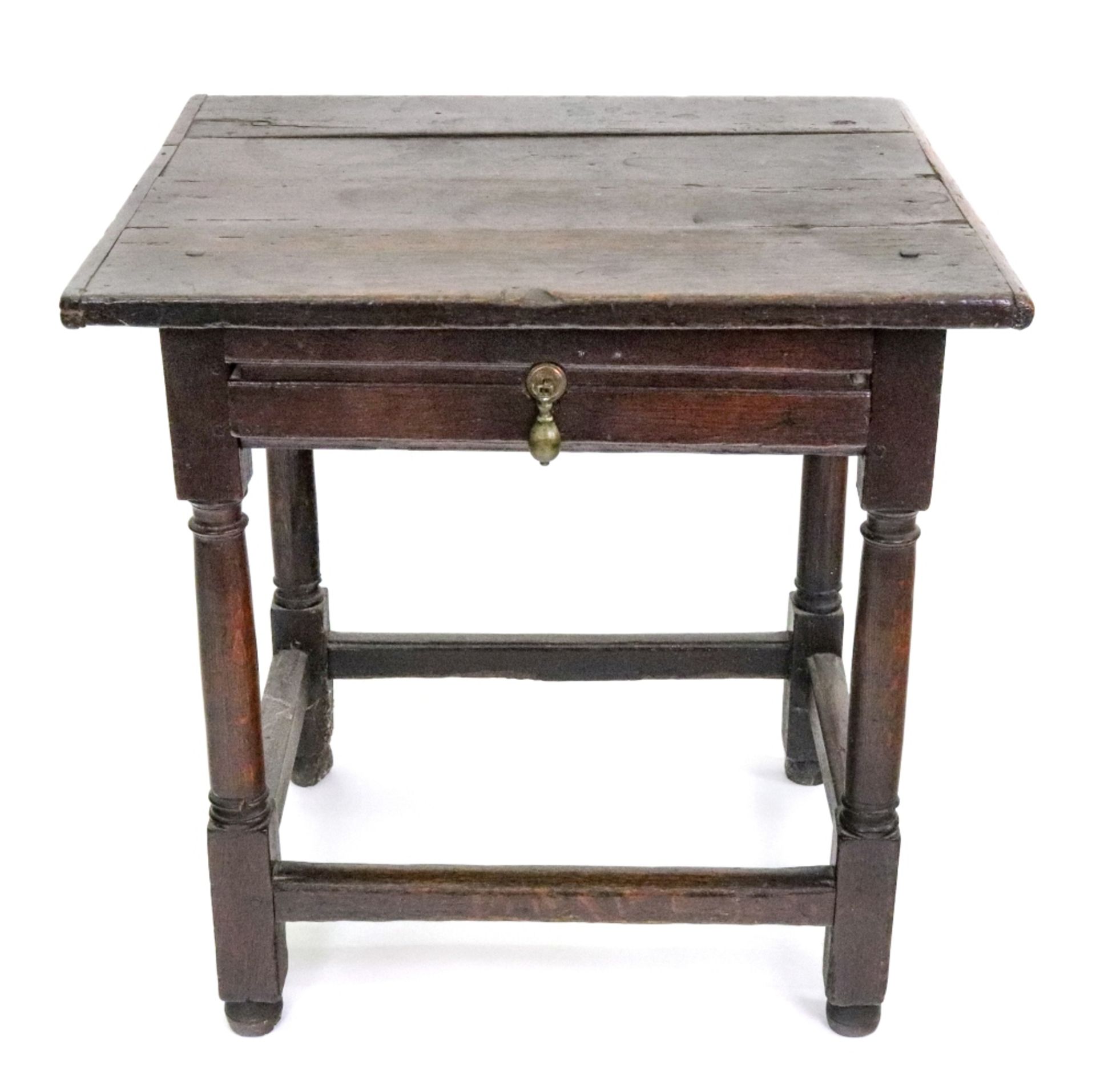 A late 17th century oak side table, the cleated planked rectangular top above a frieze drawer,