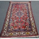 A Sarough rug, Persian, the madder field with an indigo diamond medallion, indigo outer surround,