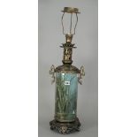 A pottery table lamp painted with dragonfly and water lily around a pond,