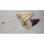 A Victorian lace parasol with ivory and pink coral handle and another with carved decoration to the