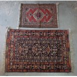 A Baluchistan rug, the black field filled with stylised flowering vases, birds; a floral border,