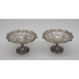 A pair of silver sweetmeat stands, each of shaped circular form, with a shell and pie-crust rim,