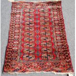 A Tekke Turkman rug, the madder field with two columns of ten guls, a sunburst border, 120cm x 82cm.