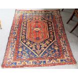 A Hamadan rug, Persian, the shaped indigo field with a hooked madder medallion,