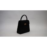 A Chanel quilted black suede evening bag with top carrying handle to a single flap fastening with