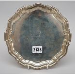 A silver salver of shaped circular form, crest and motto engraved,