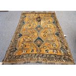 A Shiraz rug, Persian, the brown field with three connecting indigo diamonds supported by stars,