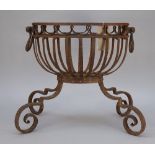 A Regency style wrought iron fire basket of oval form, with twin handles over four scroll feet,