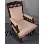 An Edwardian walnut upholstered armchair on turned supports, 66cm wide x 102cm high.
