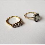 A gold and platinum, diamond set four stone ring, mounted with a row of cushion shaped diamonds,