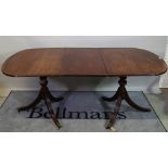 A Regency style inlaid mahogany extending dining table, one extra leaf,